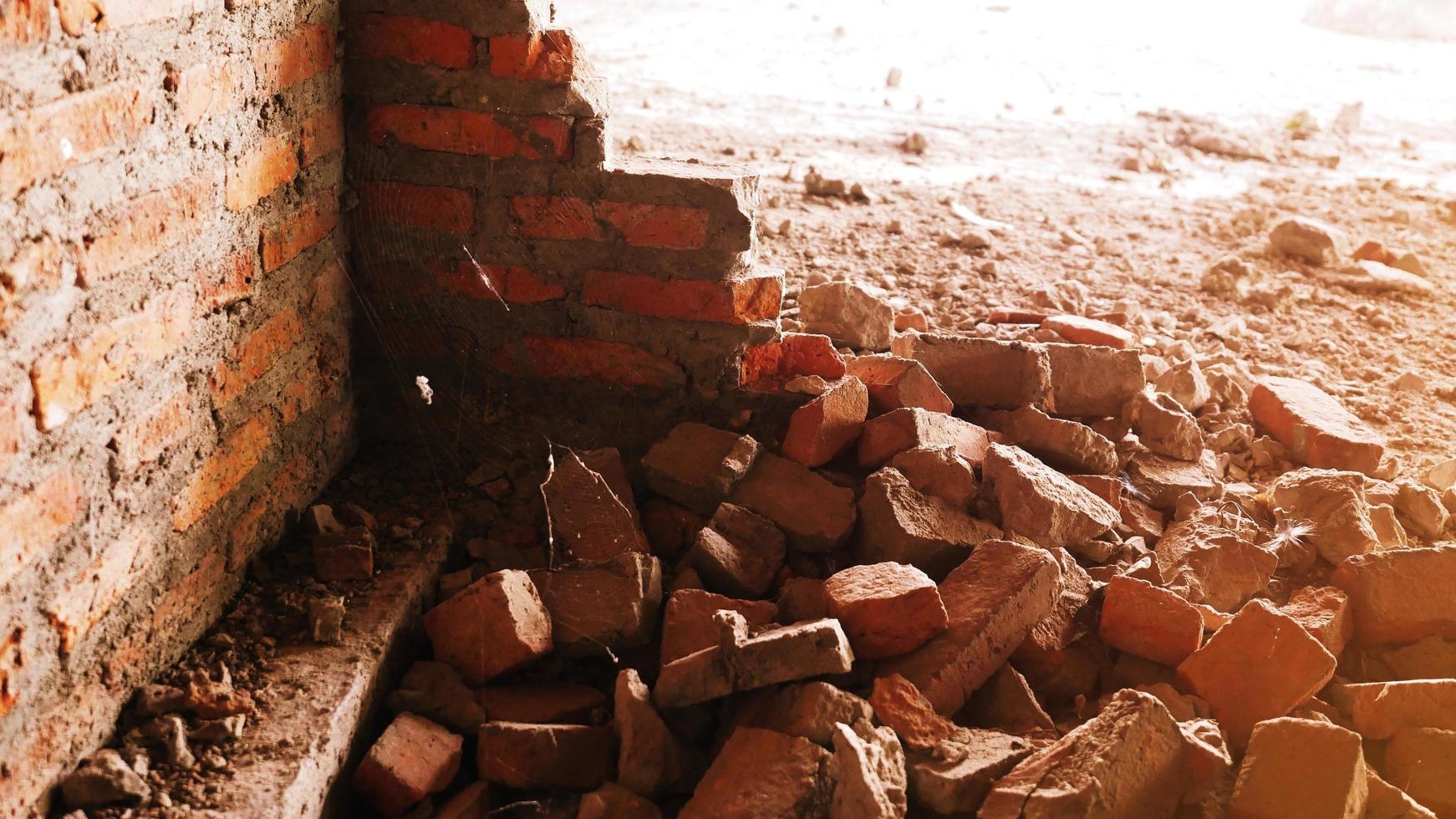 primer plano de los escombros de un edificio industrial que se derrumba en un montón de hormigón y ladrillo. y los escombros irregulares causados por la falla de los ingenieros en la construcción abandonada. foto