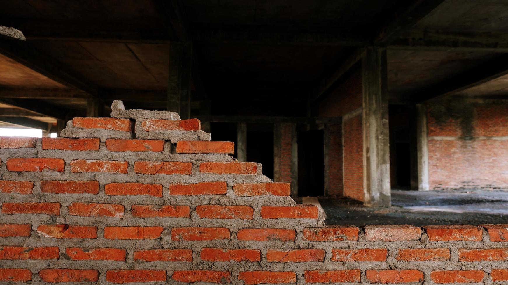 primer plano de los escombros de un edificio industrial que se derrumba en un montón de hormigón y ladrillo. y los escombros irregulares causados por la falla de los ingenieros en la construcción abandonada. foto