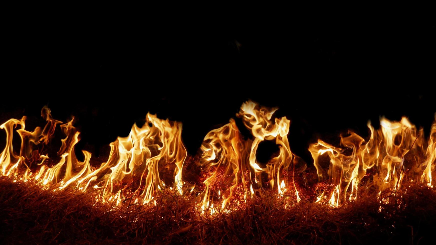 Haystack fires at night in arid areas The ash erupted and the wind was very dangerous. ashes red as hell. photo