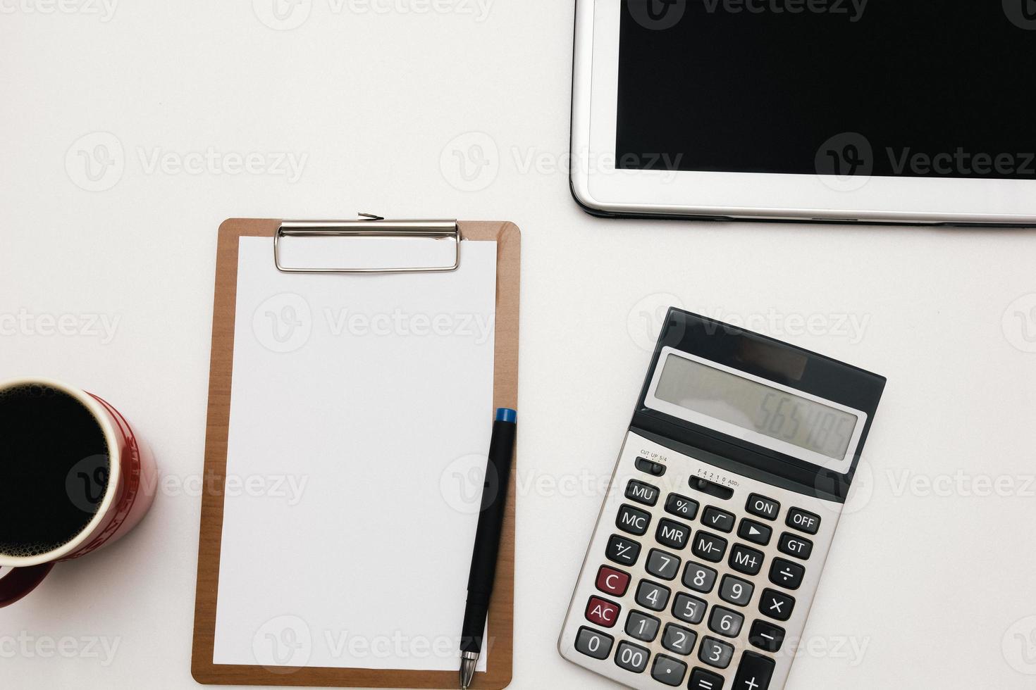 The top view of the office desk blank paper, pen, calculator, tablet. Financial planning and work concept. photo