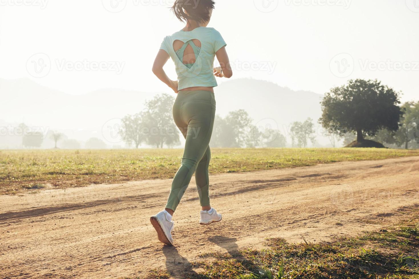 Young lady enjoying in a healthy lifestyle while jogging along a country road photo