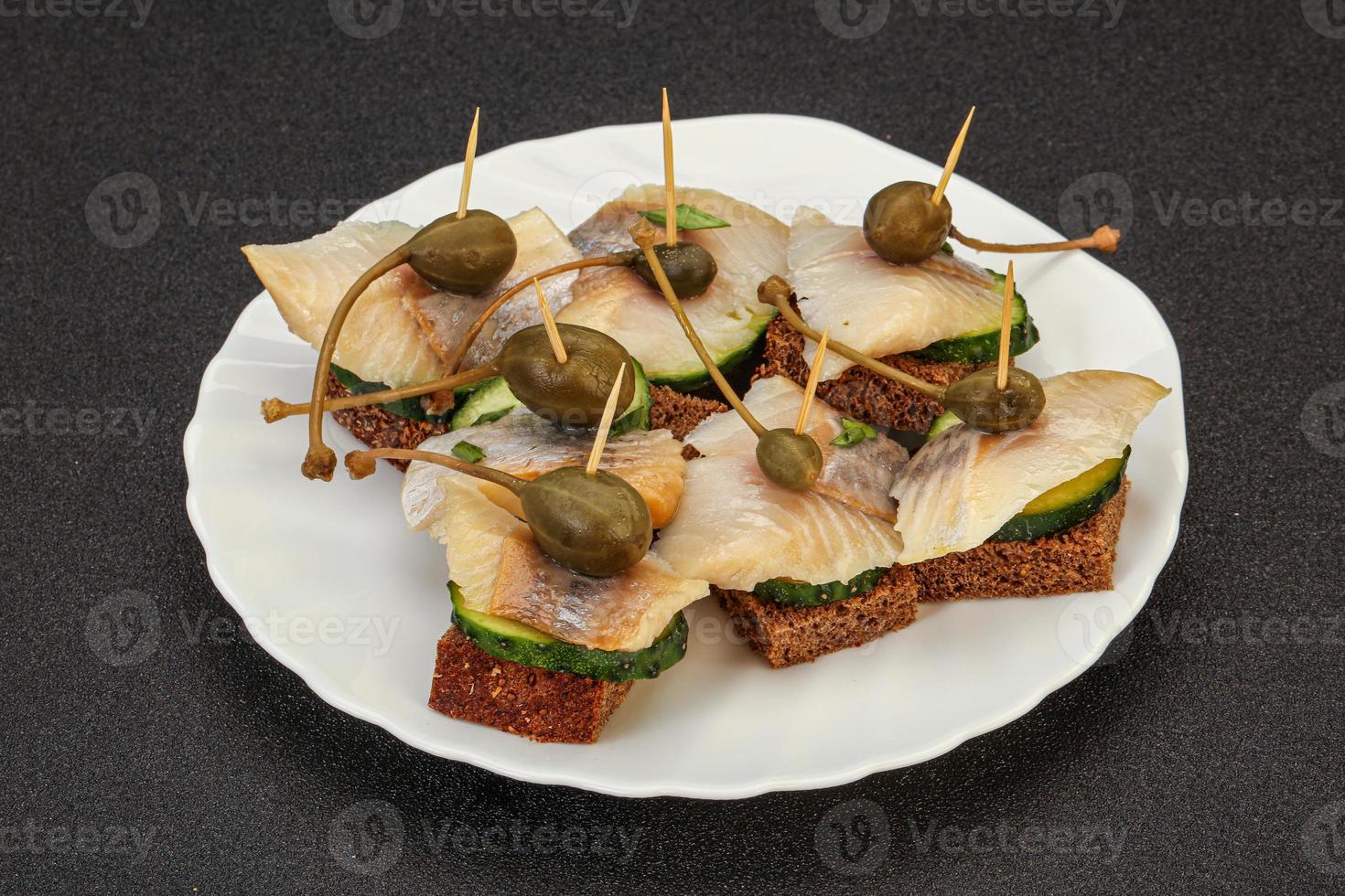 Herring fillet canape with caperberry photo
