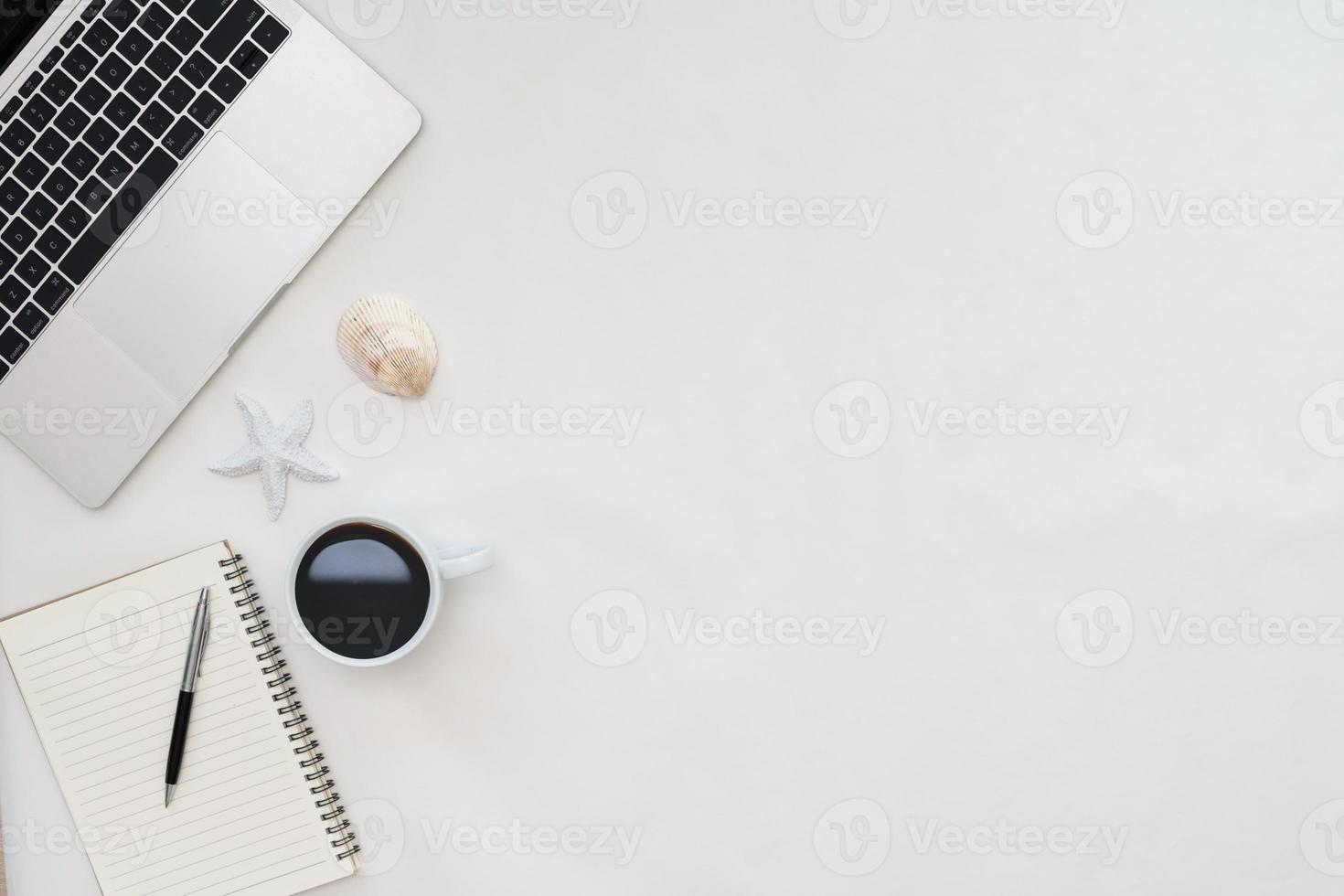Flat lay photo of office desk with laptop, notebook, pen, coffee, starfish and shells with copy space background