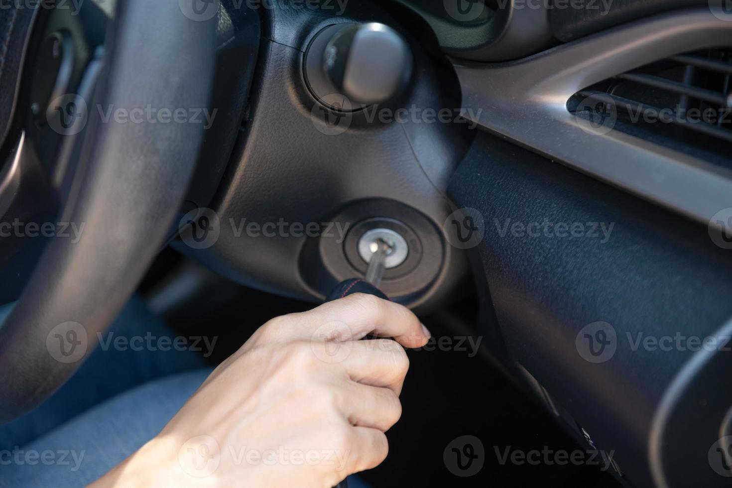 Closeup inside vehicle of hand holding key in ignition, start engine key,     woman driver starting the car engine,  the concept of buying a used car or a rental car. photo