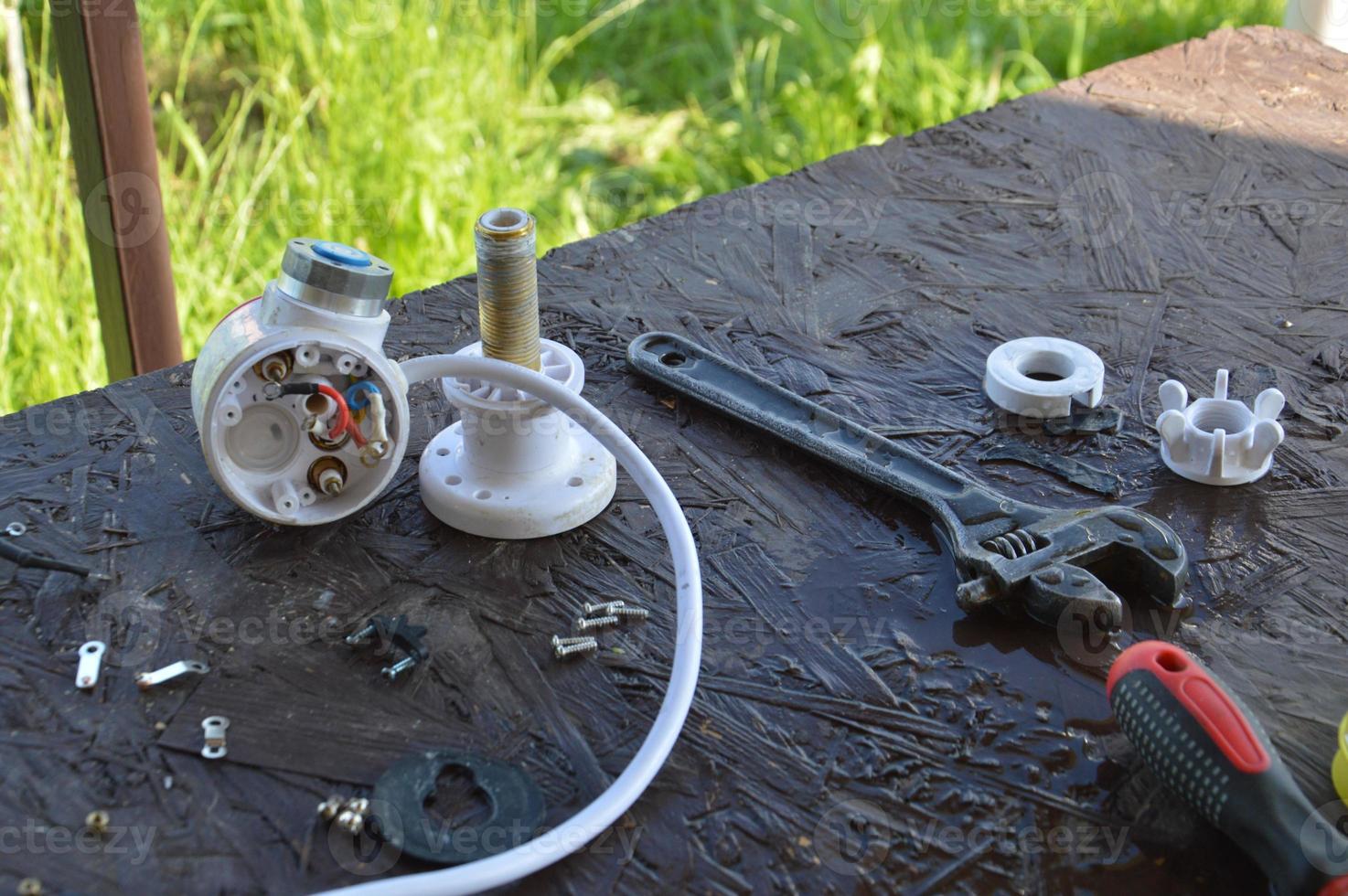 reparación del grifo que fluye del calentador de agua en la cocina foto