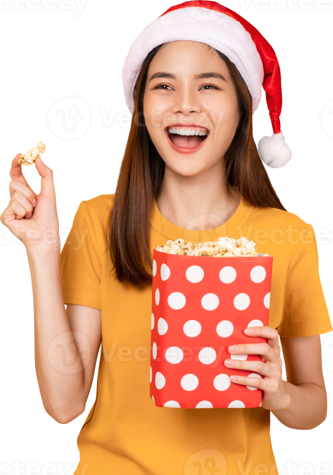 femme portant un chapeau de noël tenant un seau rouge de pop-corn tout en pointant vers l'avant. png