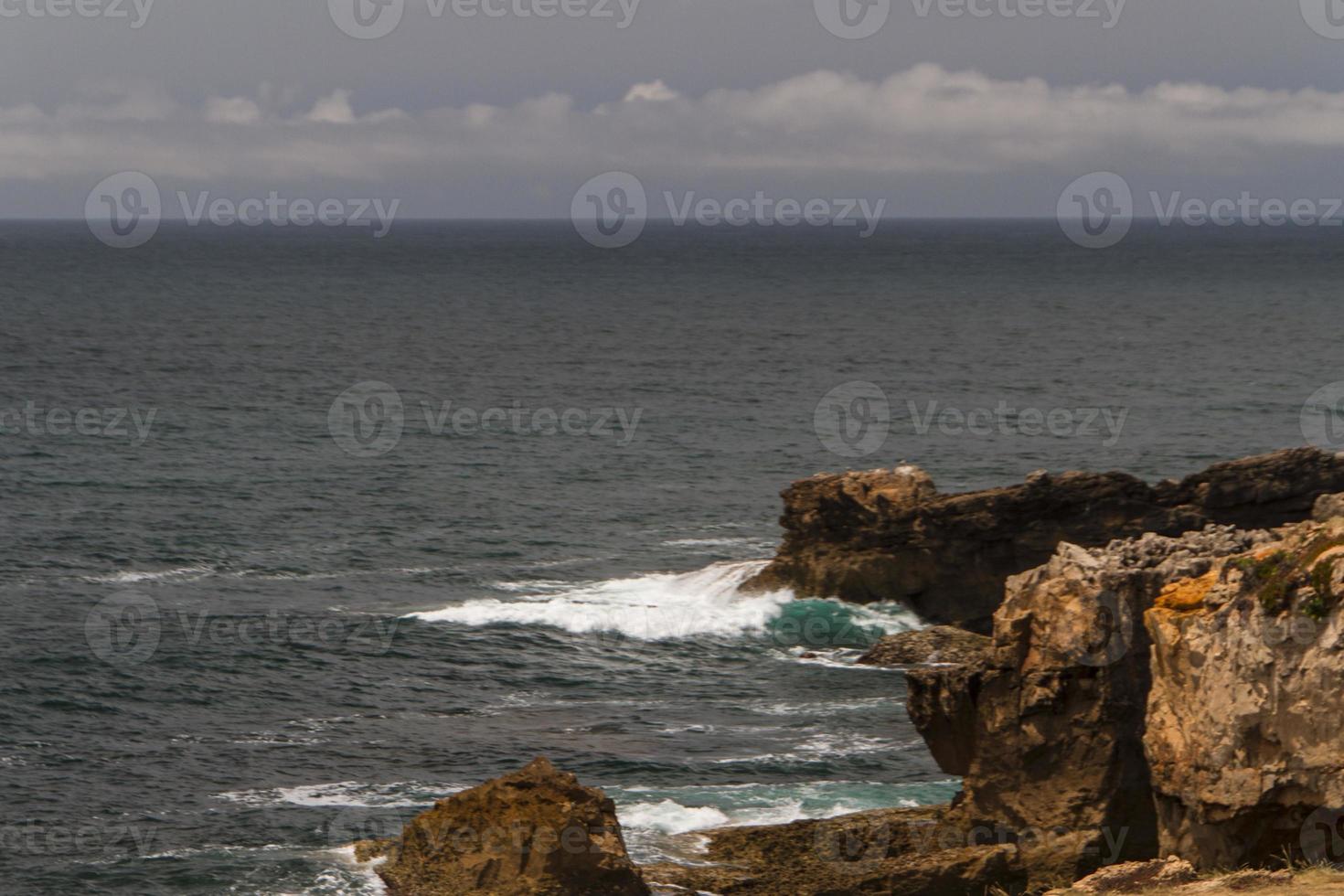 The waves fighting about deserted rocky coast of Atlantic ocean, Portugal photo