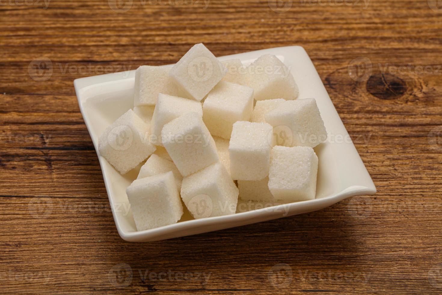 Cubos de azúcar blanco refinado en el bol foto
