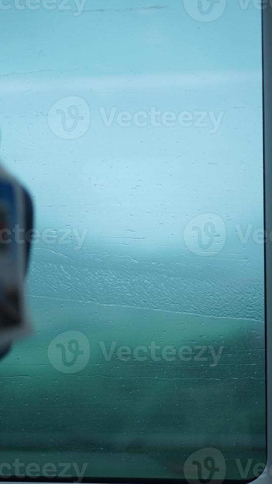 la ventana de cristal cubierta por las gotas de lluvia y la cascada en el día lluvioso foto