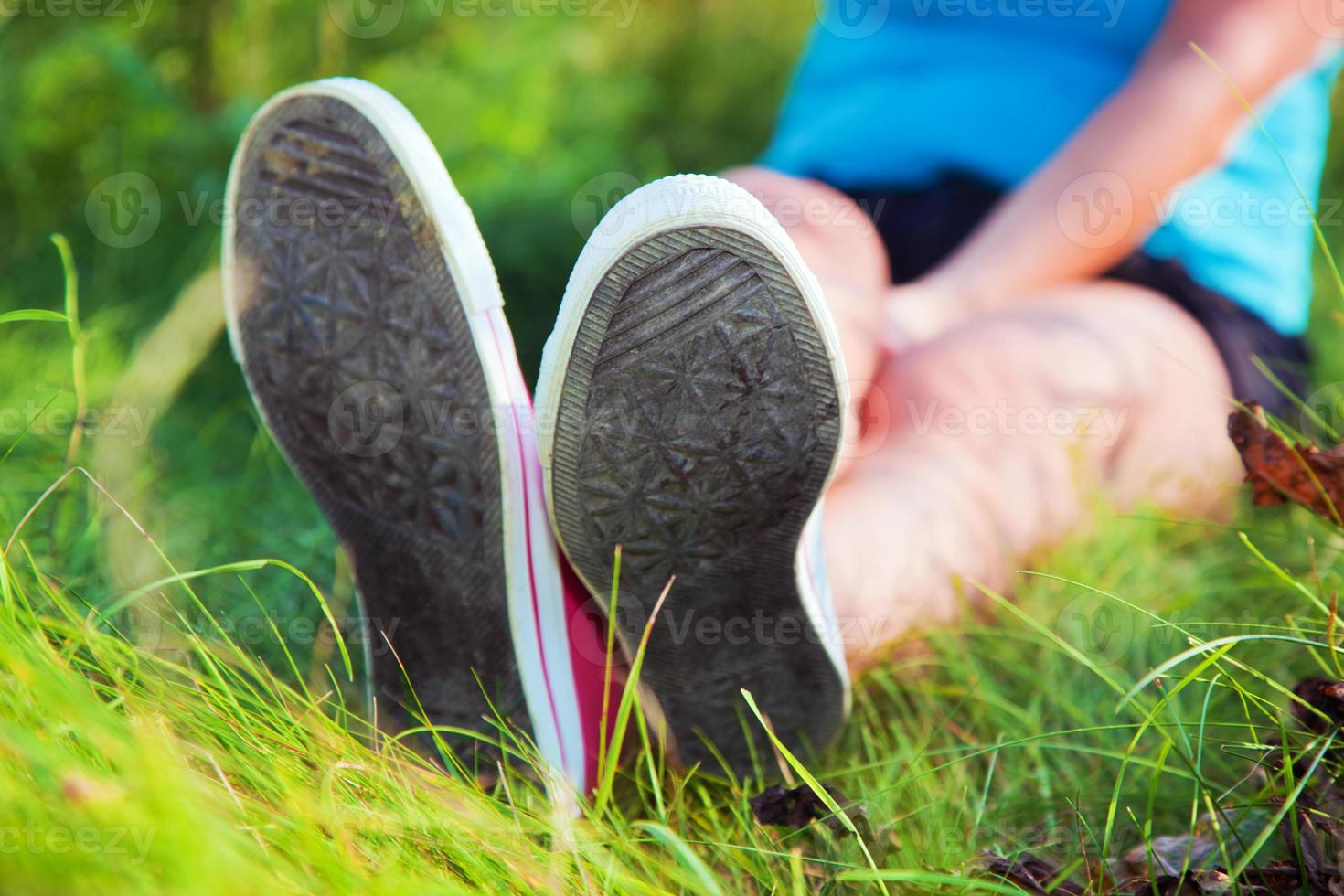 Pink sneakers on girl legs on grass photo