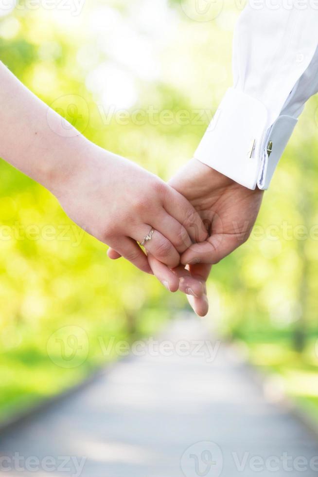 Holding hands close-up. Couple in love dating photo