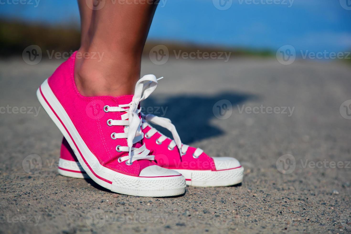 Pink sneakers on girl, woman legs photo