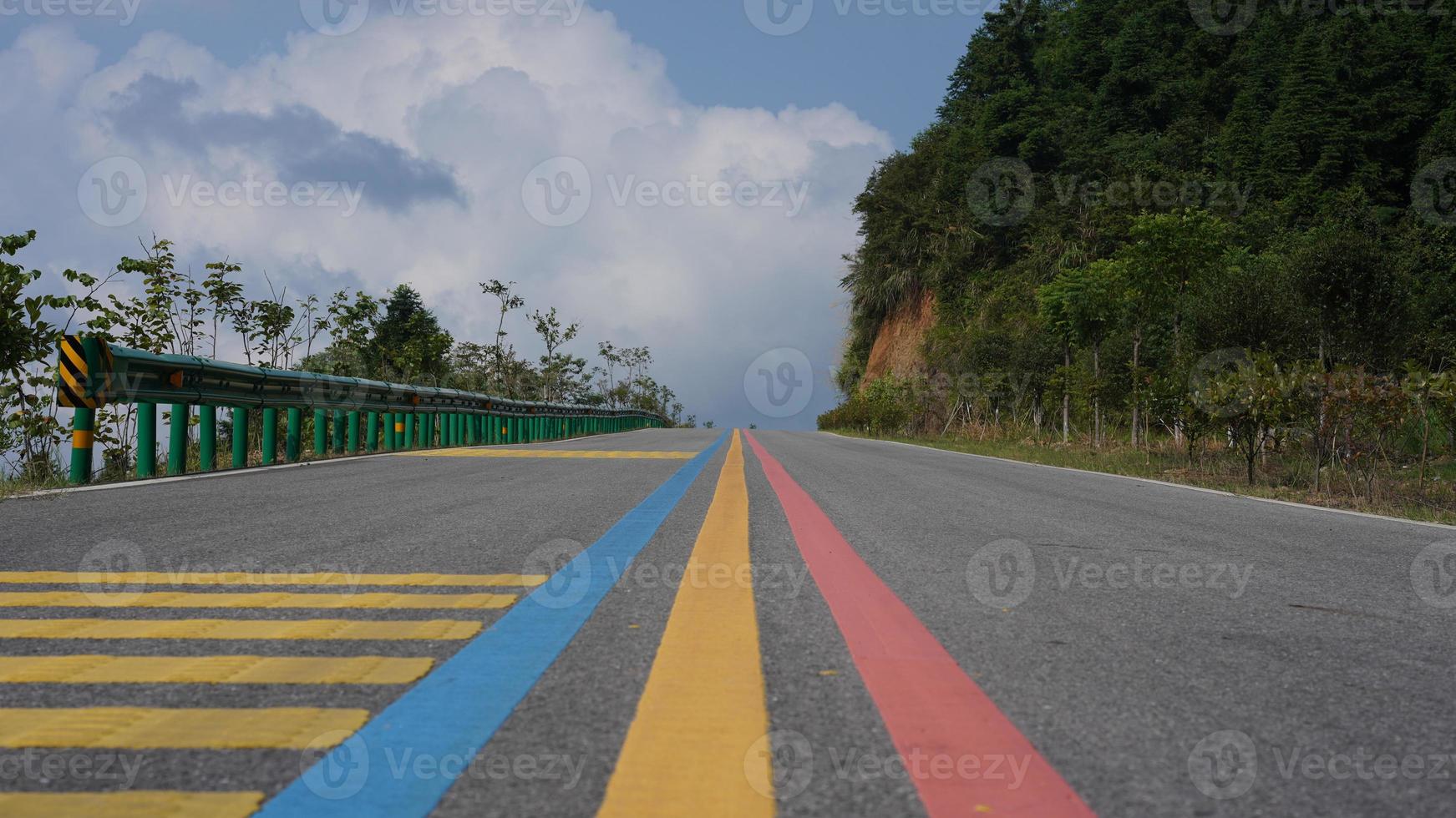 One colorful road view with the blue sky and mountains as background photo