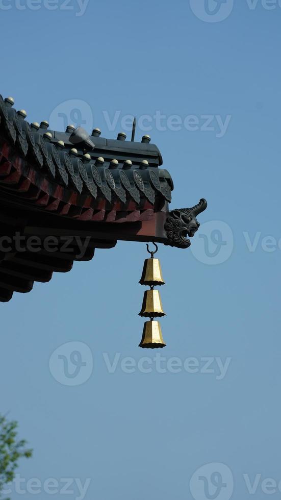 The golden bell hanging on the top of eaves in one temple of the China photo