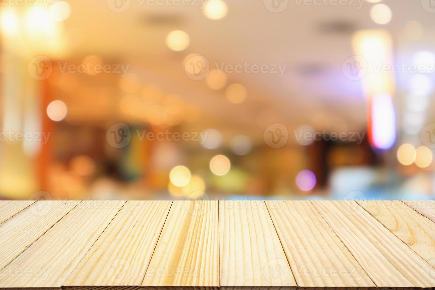 wooden table top with abstract blurred cafe restaurant bokeh lights defocused background photo