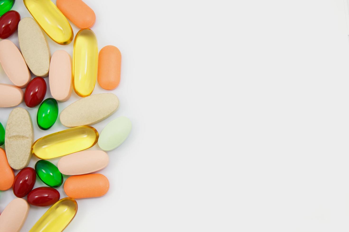 Many colorful pills on white background photo