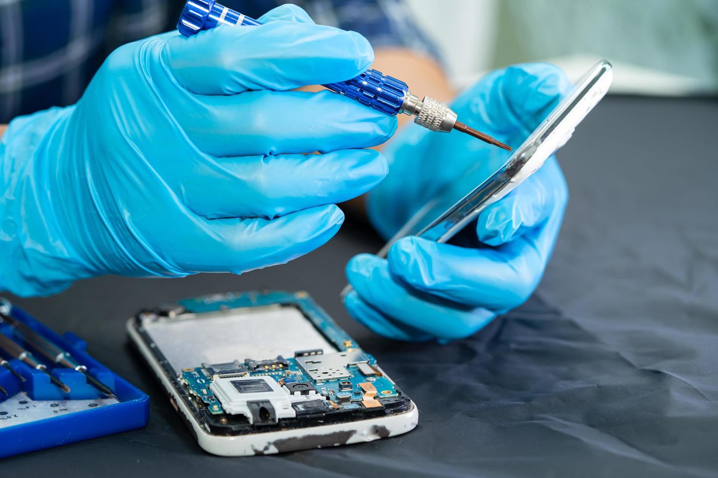 Technician repairing inside of mobile phone by soldering iron. Integrated Circuit. the concept of data, hardware, technology. photo