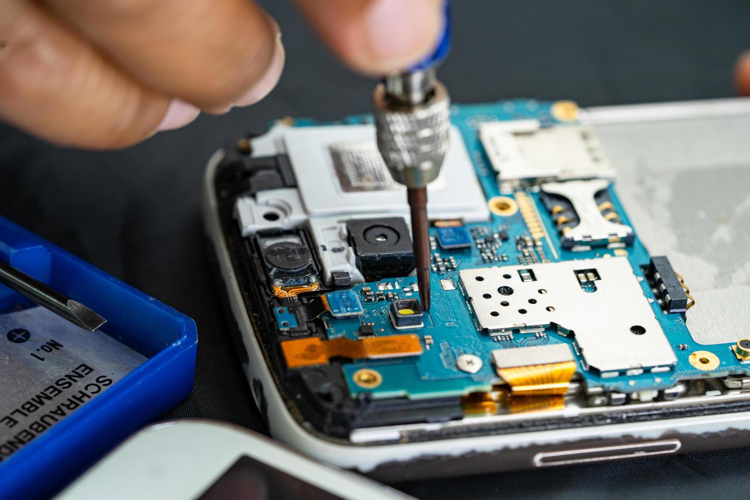 Technician repairing inside of mobile phone by soldering iron. Integrated Circuit. the concept of data, hardware, technology. photo