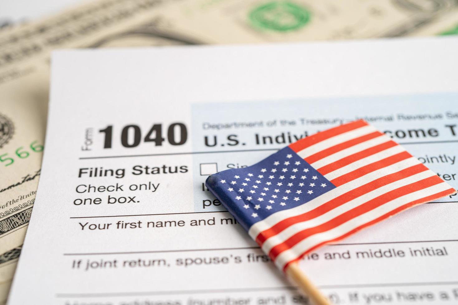 formulario de declaración de impuestos 1040 con bandera estadounidense y billete en dólares, ingreso individual estadounidense. foto