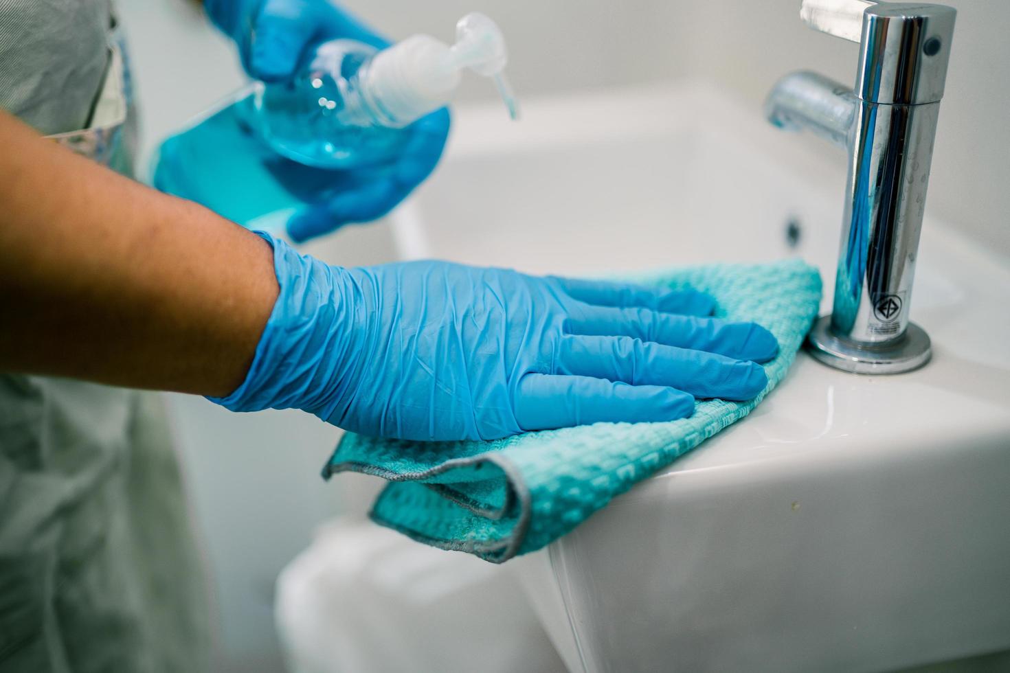 Maid cleaning wash and scrub basin in toilet at home. photo