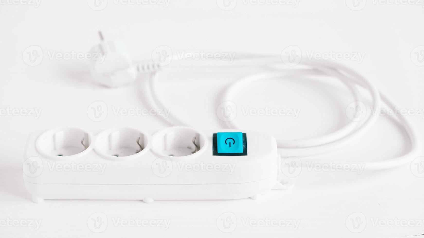 Modern white electric extension cord with a button on a white background photo