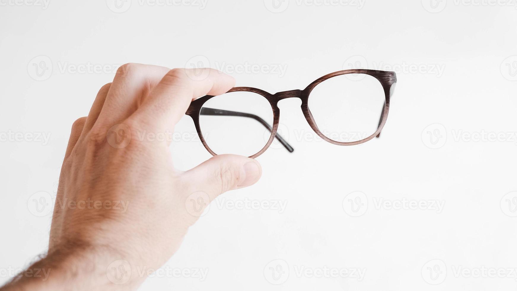 Round optical glasses in hand on a white background photo