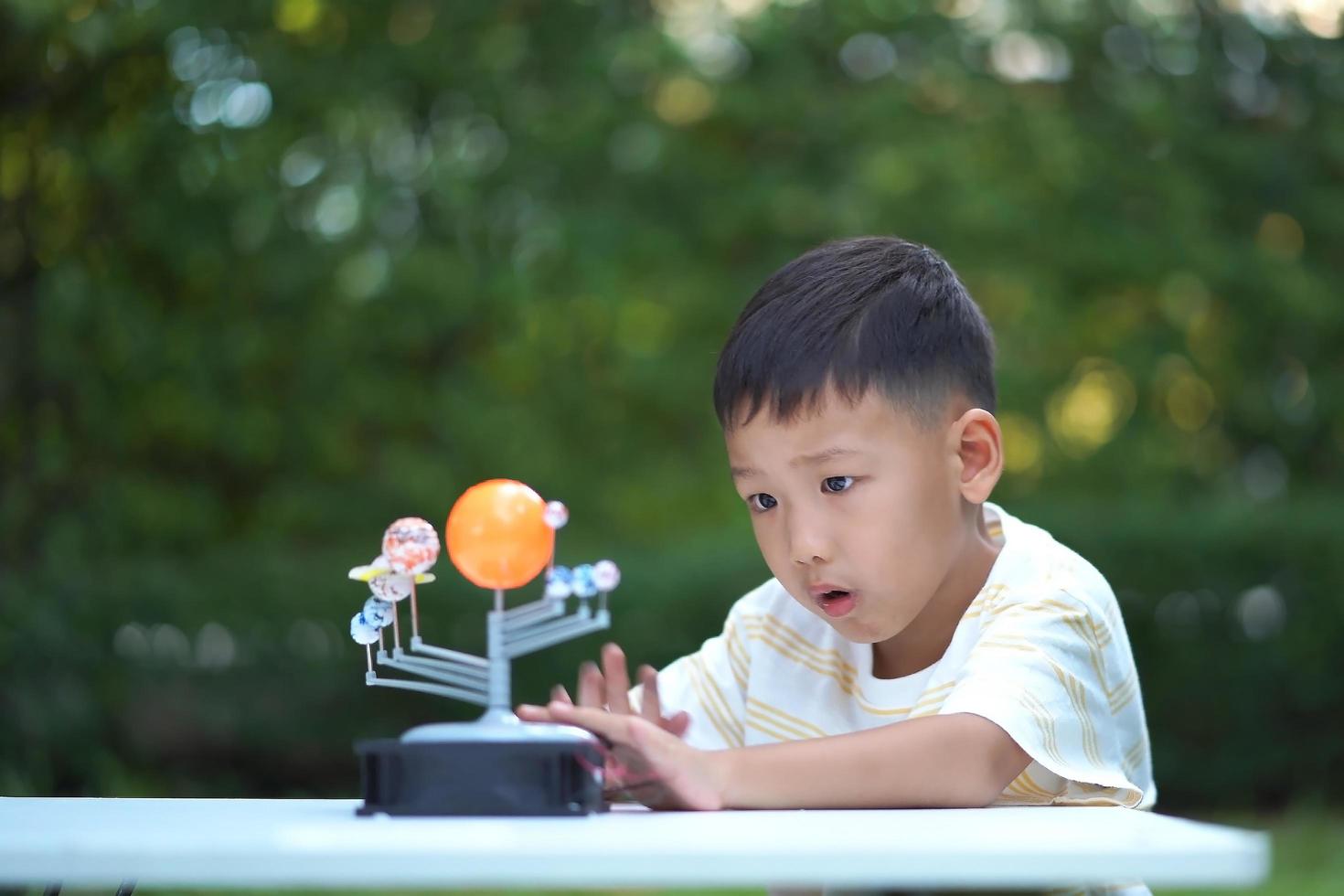 Asian boy Living Solar System Toys, Home Learning Equipment, during new normal change after coronavirus or post covid-19 outbreak pandemic situation photo