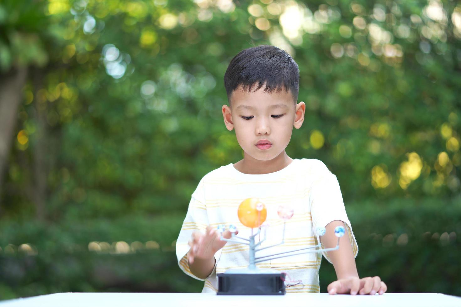 Asian boy Living Solar System Toys, Home Learning Equipment, during new normal change after coronavirus or post covid-19 outbreak pandemic situation photo