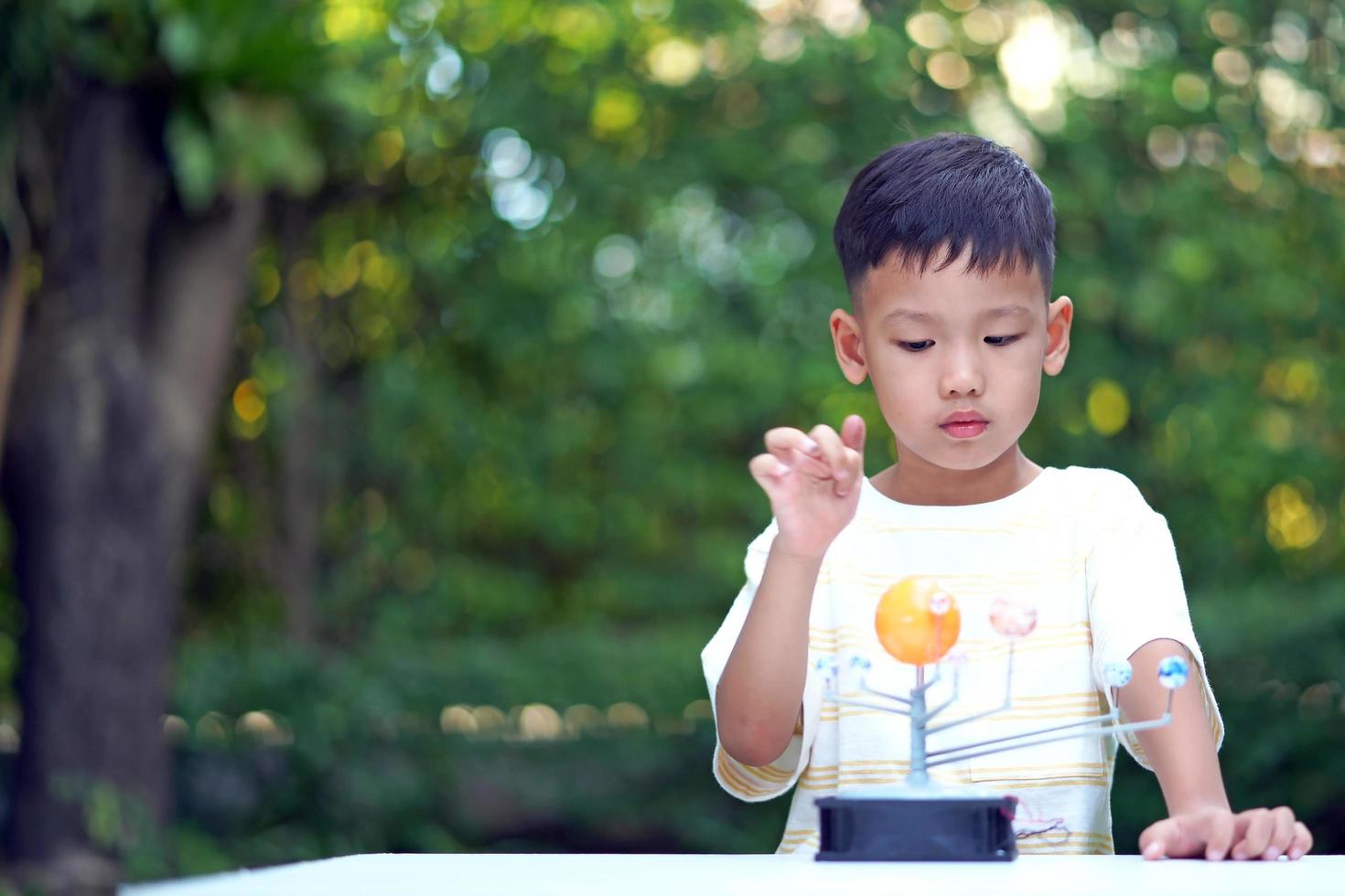 Asian boy Living Solar System Toys, Home Learning Equipment, during new normal change after coronavirus or post covid-19 outbreak pandemic situation photo