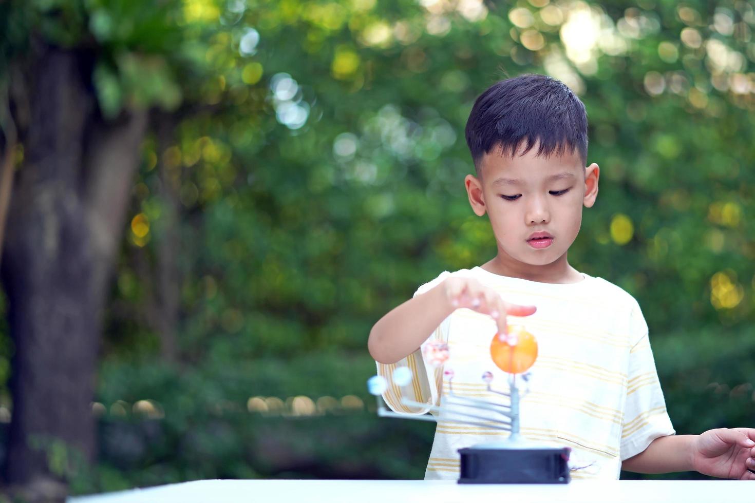 Asian boy Living Solar System Toys, Home Learning Equipment, during new normal change after coronavirus or post covid-19 outbreak pandemic situation photo