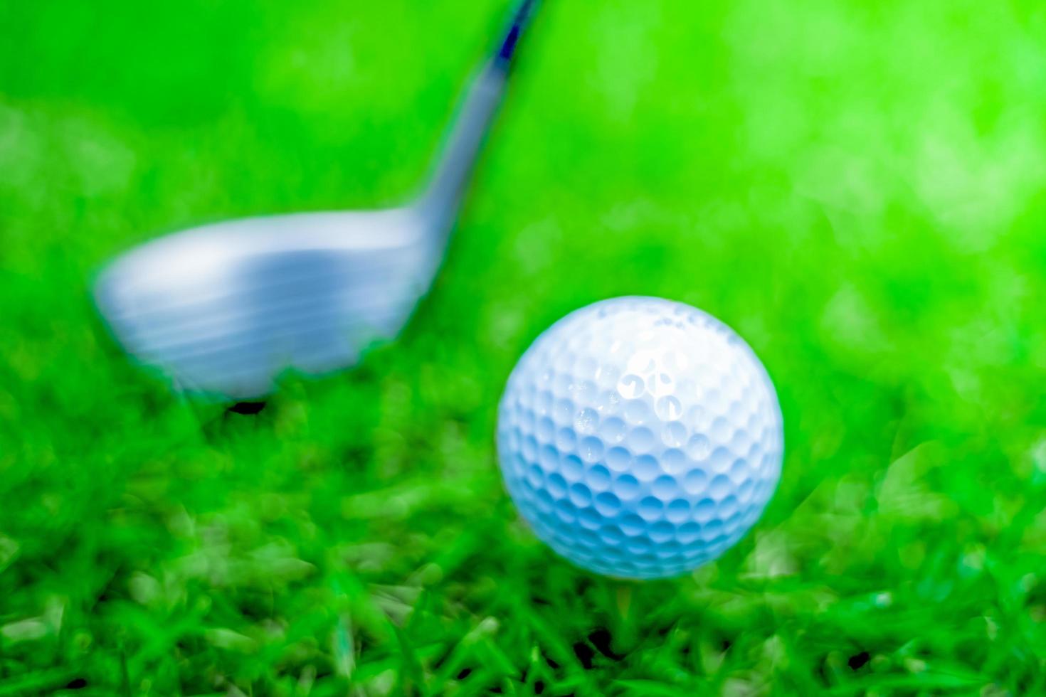 golf ball close-up in soft focus at sunlight with Green grass. wide landscape as background ,Sport playground for golf club concept.shallow focus effect. photo