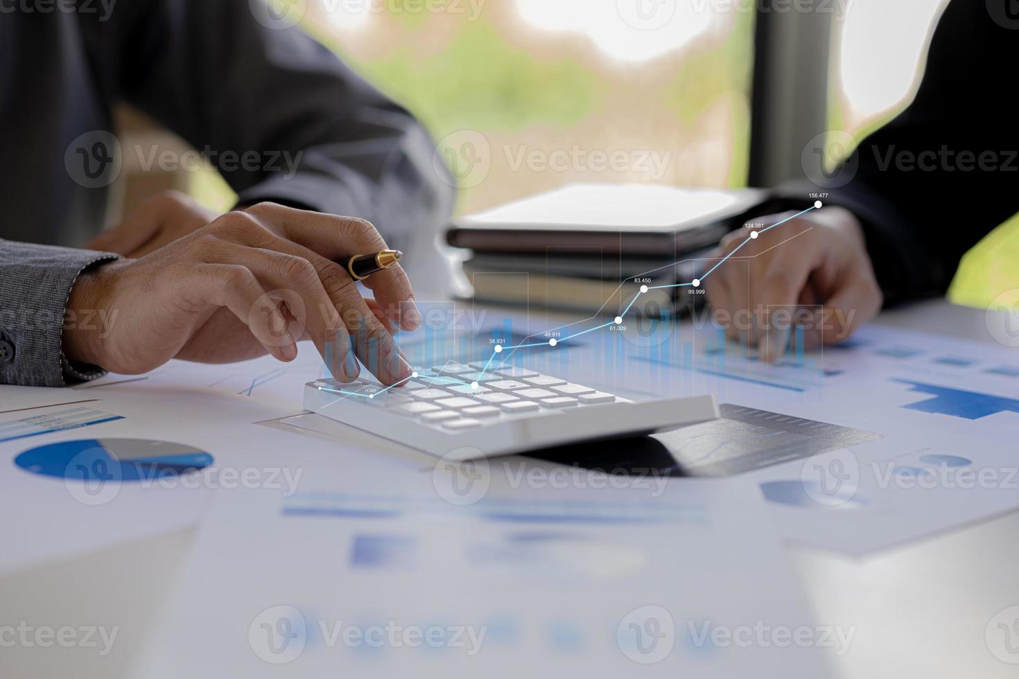 dos hombres de negocios se reúnen, señalan documentos financieros para discutir planes y soluciones, gráficos de gráficos que muestran el estado financiero y el rendimiento. concepto de administración de empresas. foto