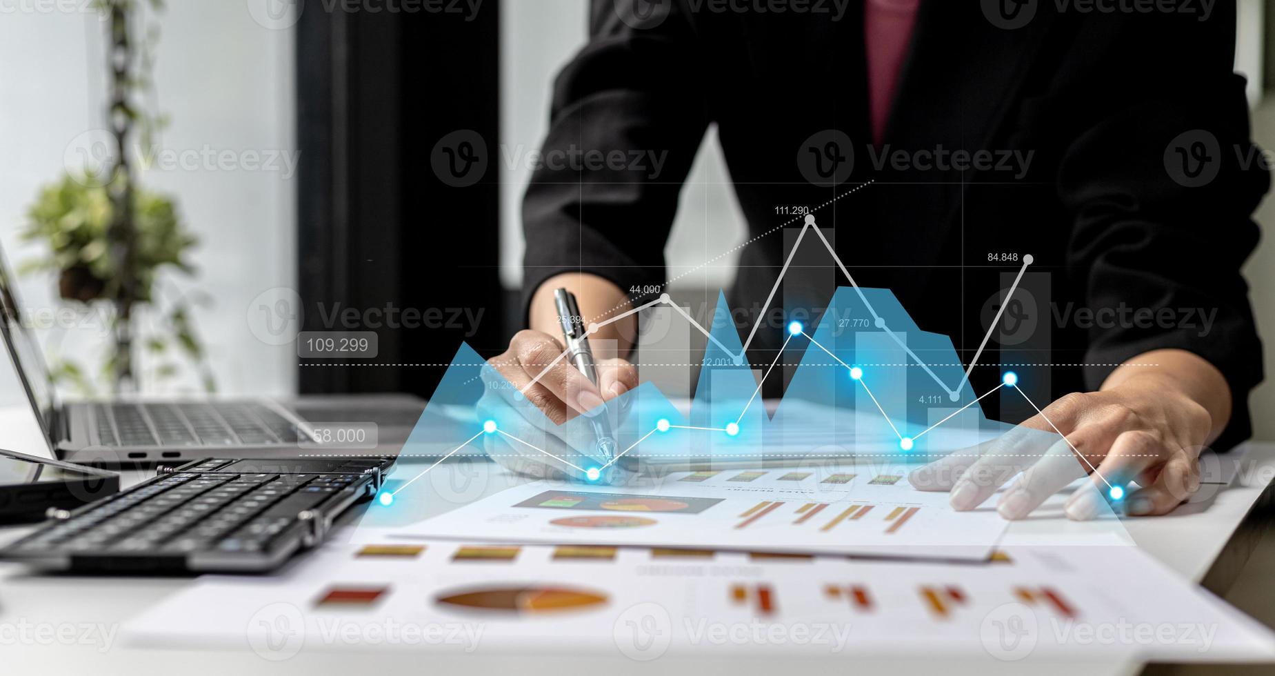 A businesswoman examines data on financial documents, company financial reports, graphics showing financial and numerical growth data. The concept of financial management to grow and be profitable. photo