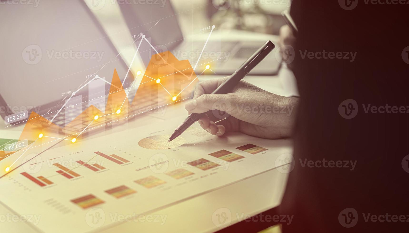 A businesswoman examines data on financial documents, company financial reports, graphics showing financial and numerical growth data. The concept of financial management to grow and be profitable. photo