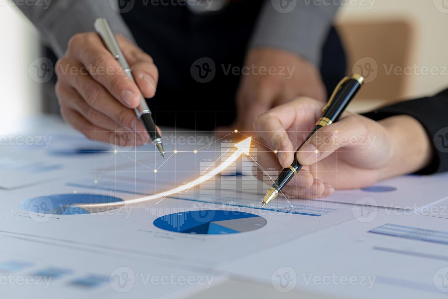 Two businessmen are meeting together, they point to financial documents to discuss plans and solutions, chart graphics showing financial status and performance. Business administration concept. photo