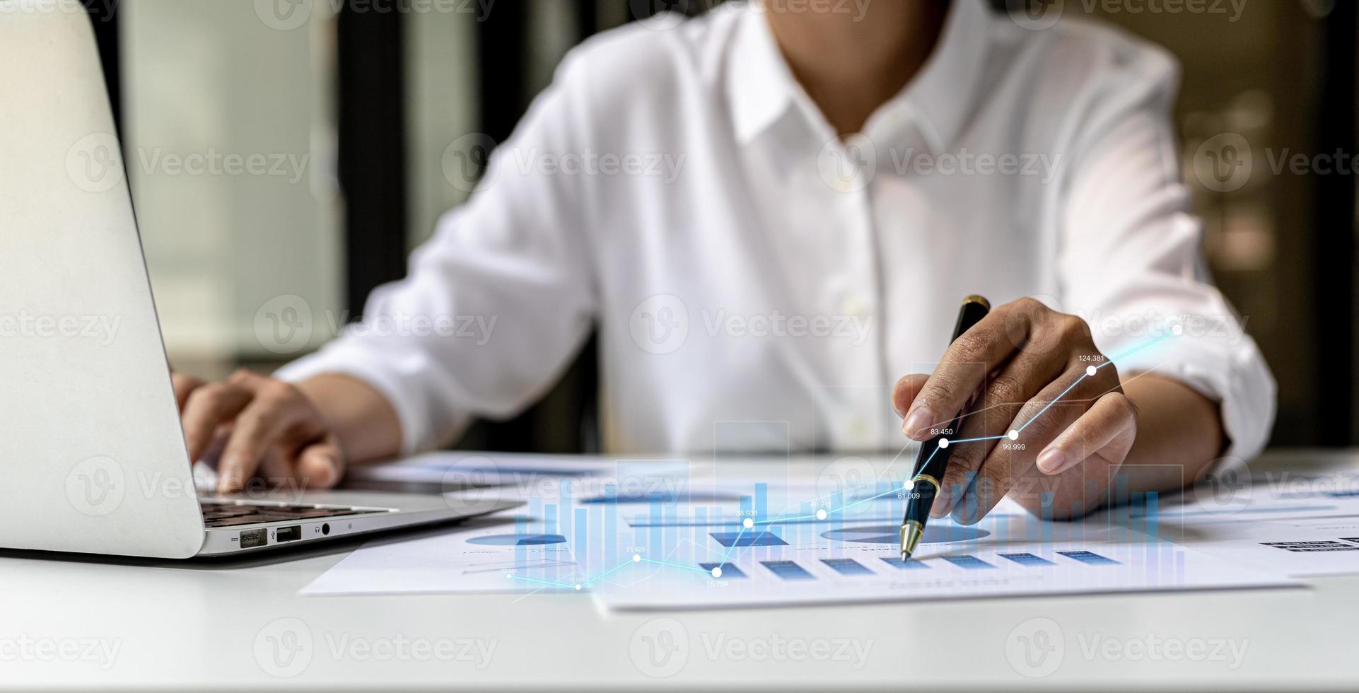 A business man examines data on financial documents, company financial reports, graphics showing financial and numerical growth data. The concept of financial management to grow and be profitable. photo