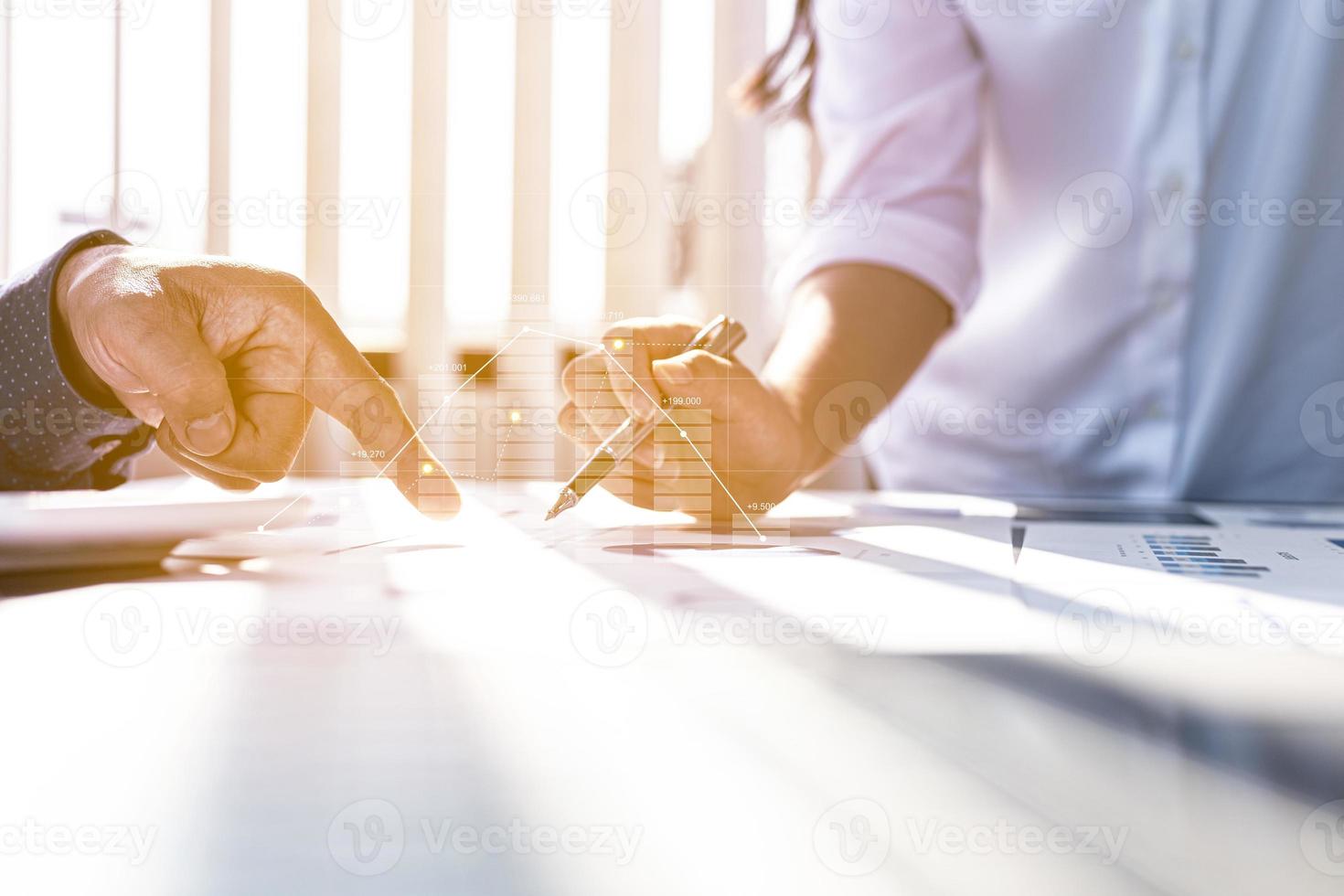 Two businessmen are meeting together, they point to financial documents to discuss plans and solutions, chart graphics showing financial status and performance. Business administration concept. photo