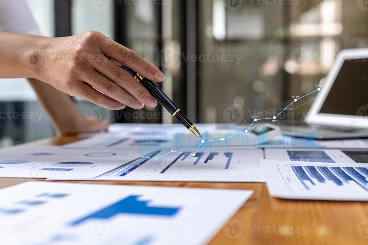 A business man examines data on financial documents, company financial reports, graphics showing financial and numerical growth data. The concept of financial management to grow and be profitable. photo
