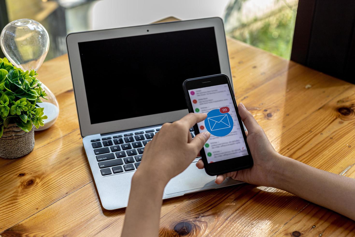 Person holding a smartphone at the screen showing an email application, using a smartphone to send and receive electronic mail. Concept of using smartphones and sending and receiving emails online. photo