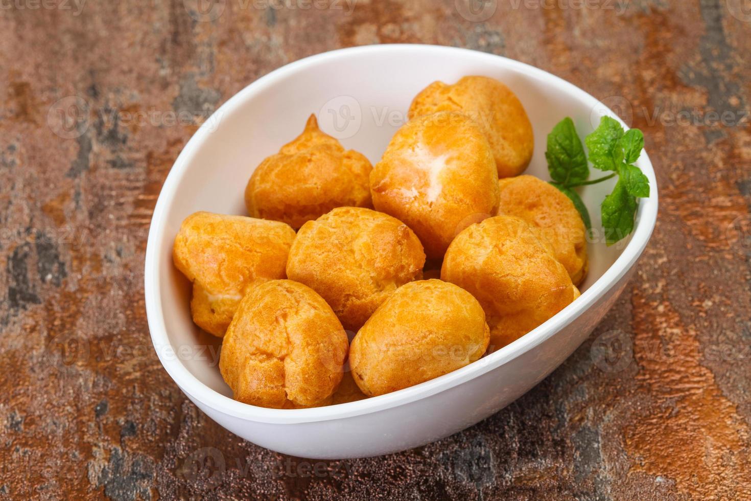 Sweet tasty profiteroles heap in the bowl photo