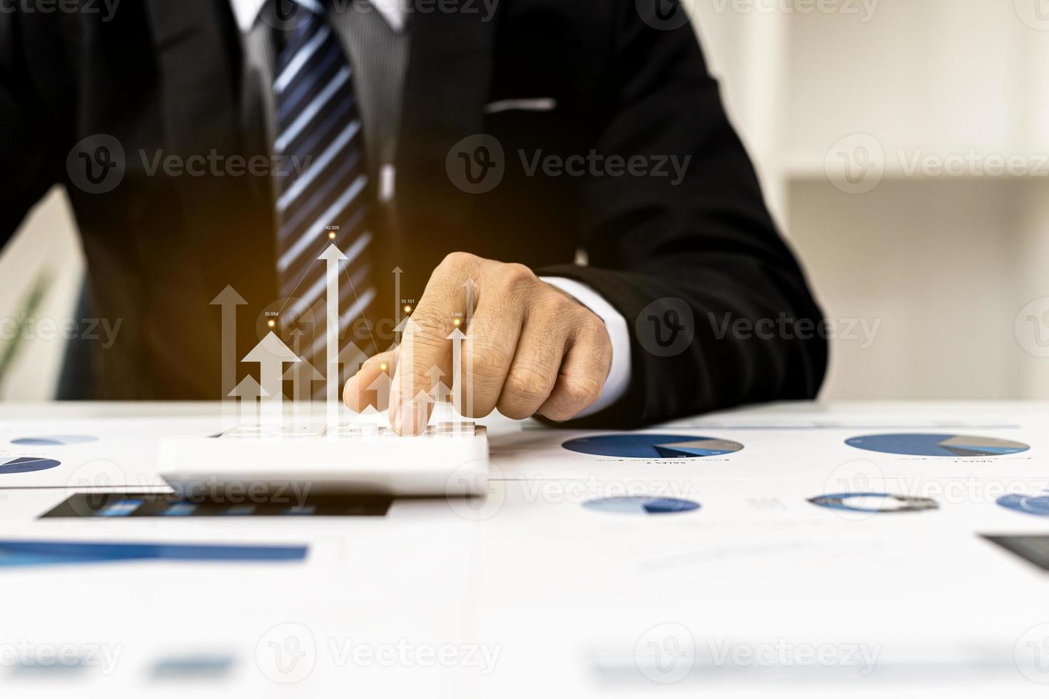 Businesswoman presses a calculator to check data on documents, company financial reports, graphics showing financial and numerical growth data. Financial management to grow and be a profitable concept photo