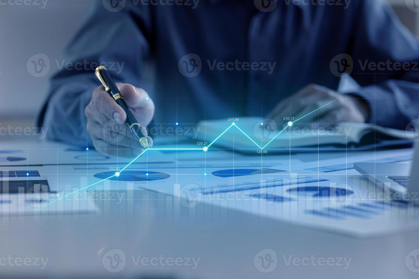 A business man examines data on financial documents, company financial reports, graphics showing financial and numerical growth data. The concept of financial management to grow and be profitable. photo