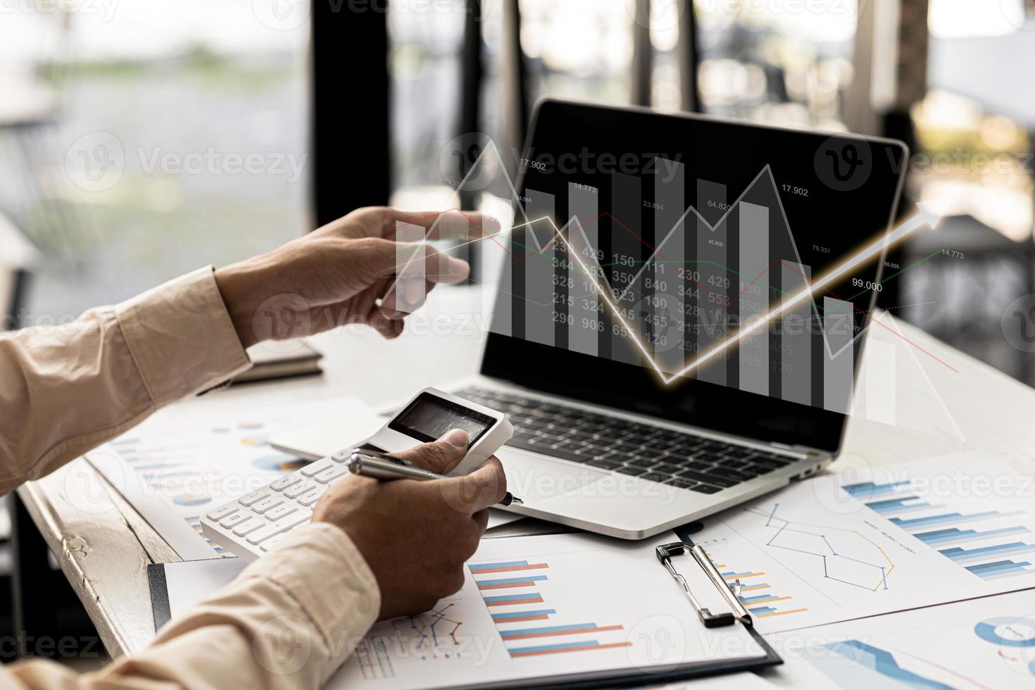 A business man examines data on financial documents, company financial reports, graphics showing financial and numerical growth data. The concept of financial management to grow and be profitable. photo