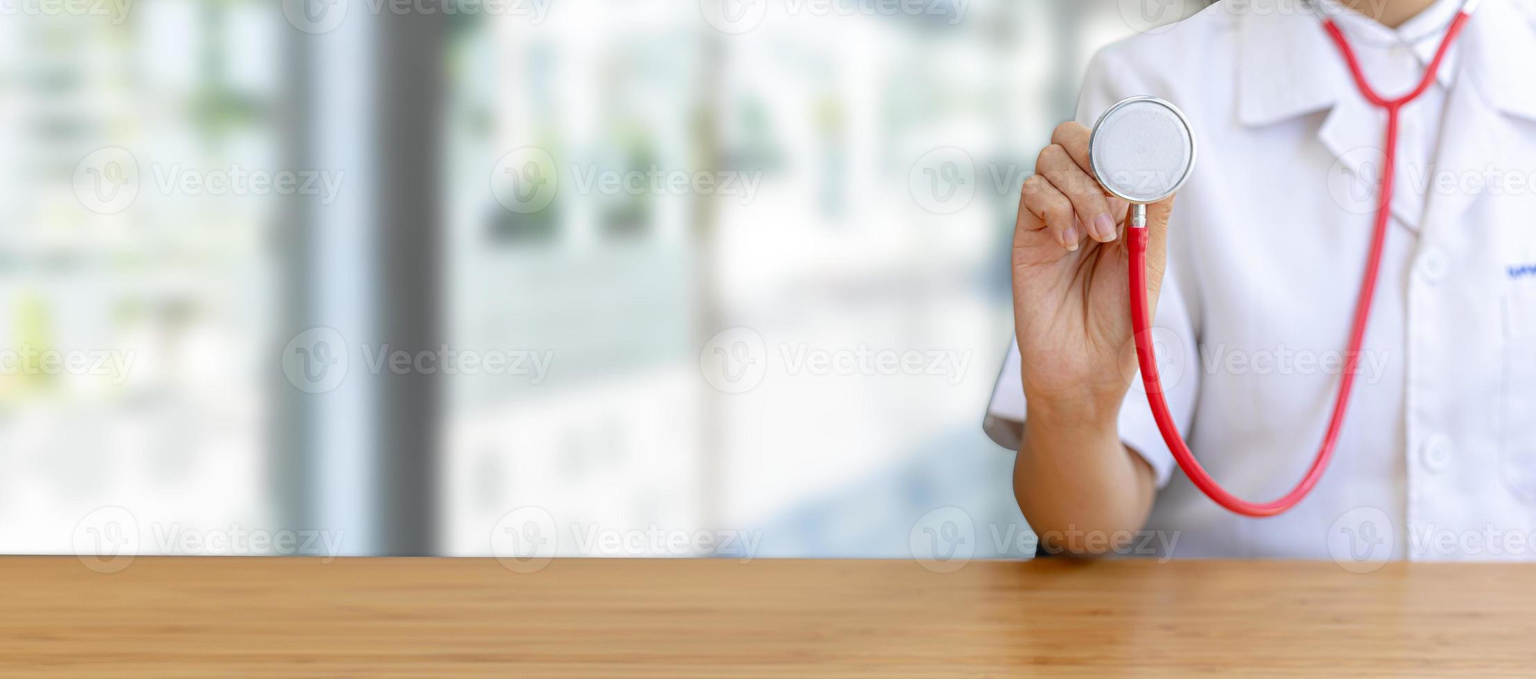 médico sosteniendo un estetoscopio en el fondo de un hospital. conceptos médicos y servicios de atención hospitalaria de calidad. fondo de banner con espacio de copia. foto