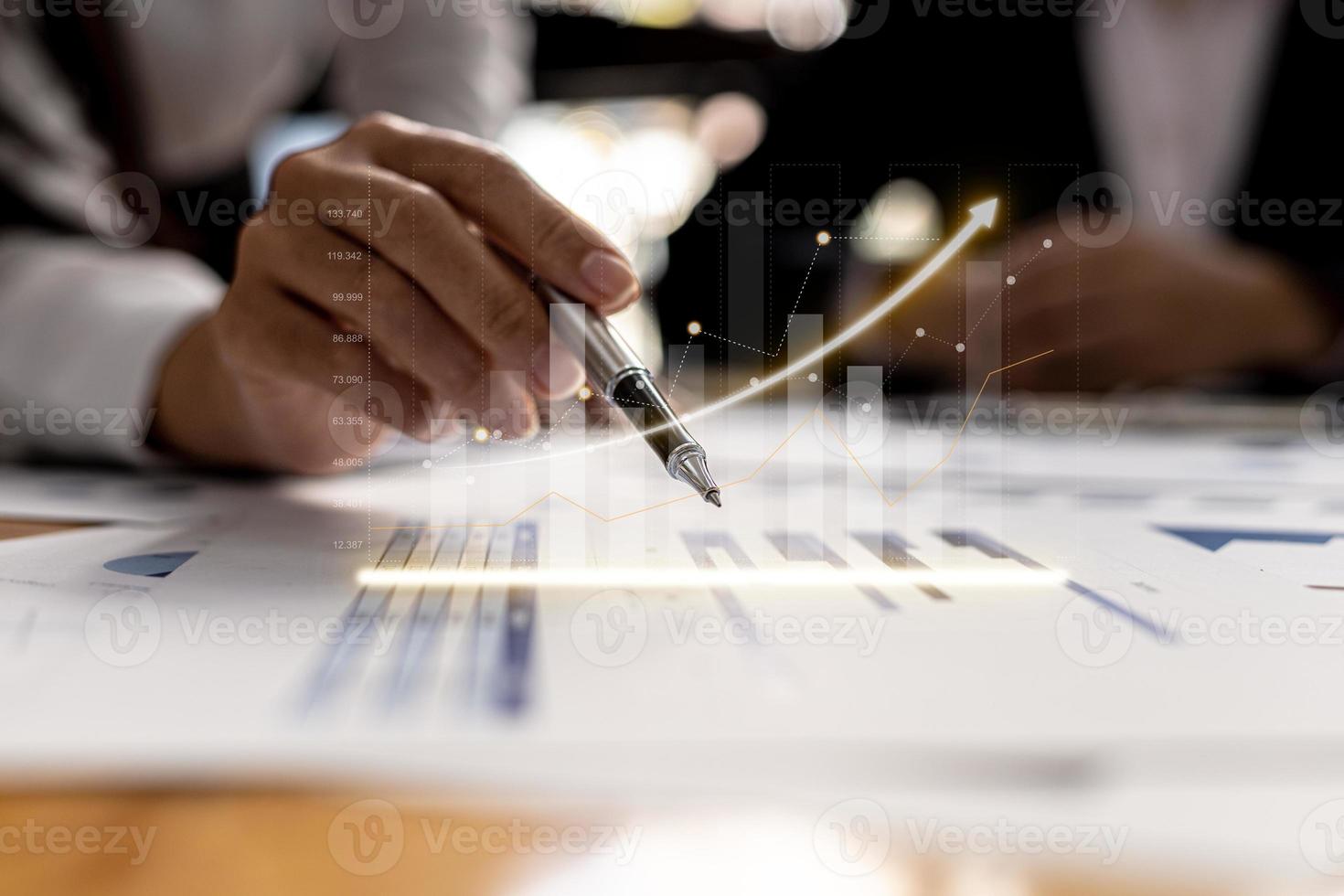 Two businessmen are meeting together, they point to financial documents to discuss plans and solutions, chart graphics showing financial status and performance. Business administration concept. photo