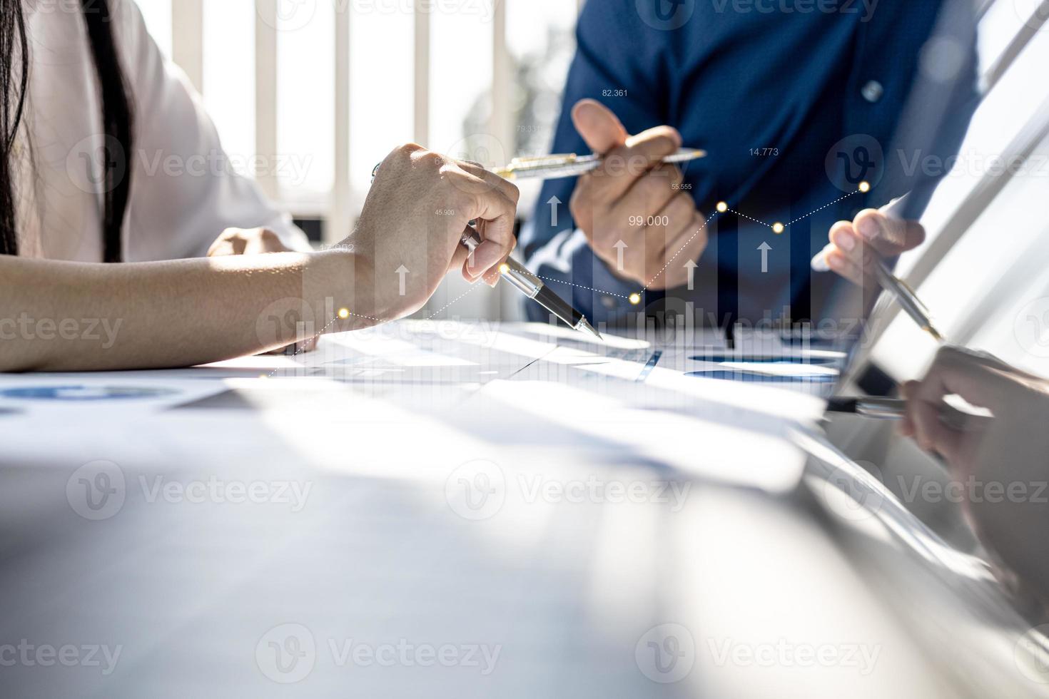 Two businessmen are meeting together, they point to financial documents to discuss plans and solutions, chart graphics showing financial status and performance. Business administration concept. photo