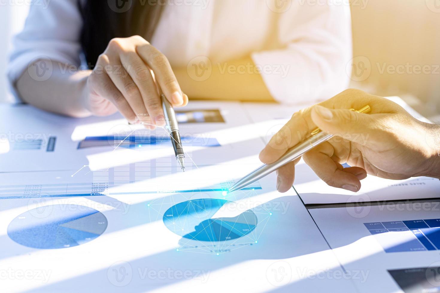 dos hombres de negocios se reúnen, señalan documentos financieros para discutir planes y soluciones, gráficos de gráficos que muestran el estado financiero y el rendimiento. concepto de administración de empresas. foto