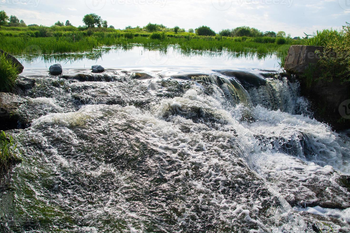 a small river waterfall on a bright sunny summer day. photo