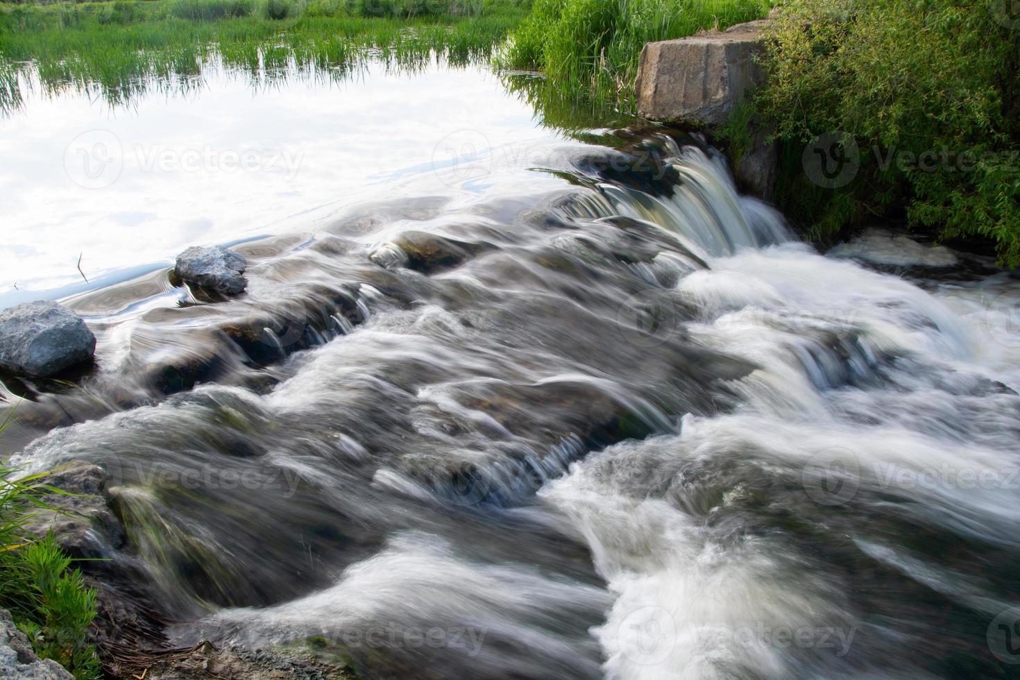 a small river waterfall on a bright sunny summer day. photo