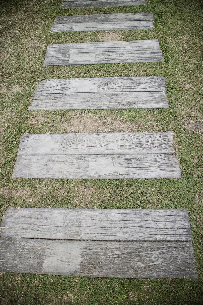 Old wood with lawn in the park,Old wooden walkway in the park. photo